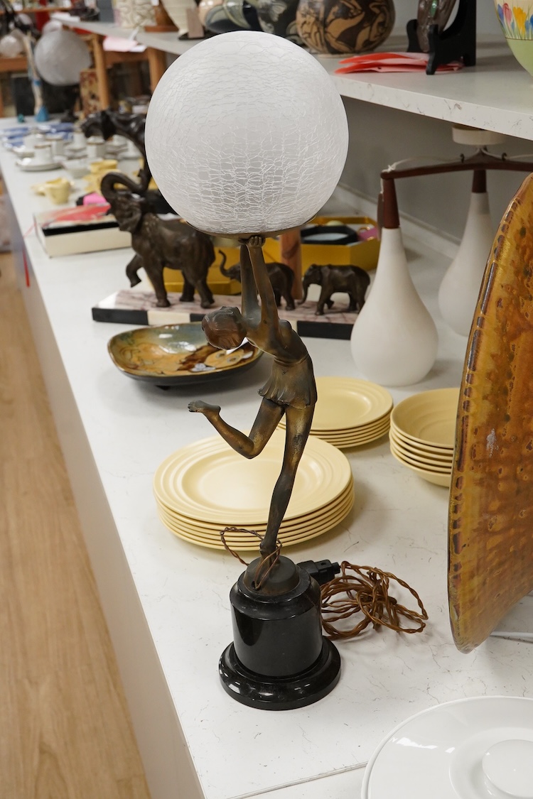 An Art Deco spelter ‘Dancing Girl’ table lamp with a frosted glass globe shade, 57cm high